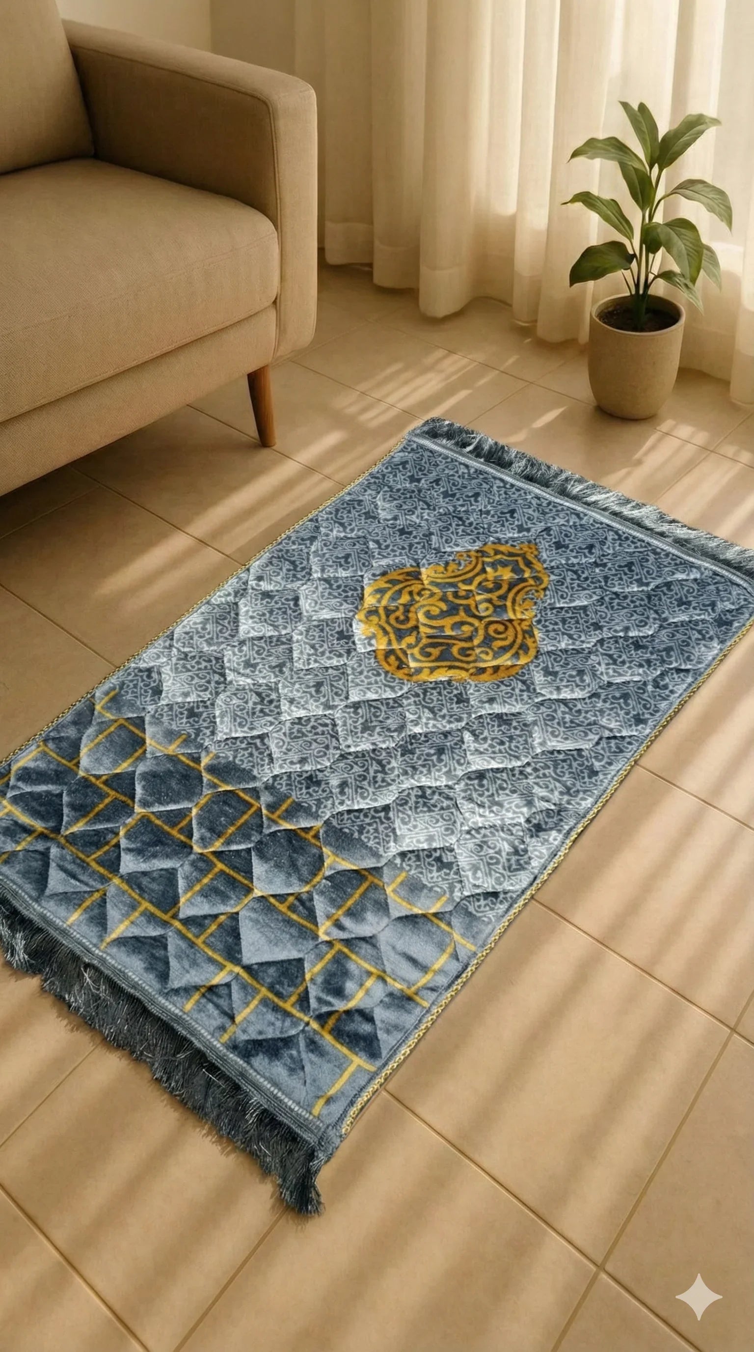 Soft velvet Islamic prayer mat with blue, gray, and gold geometric design on tiled floor next to beige sofa and potted plant